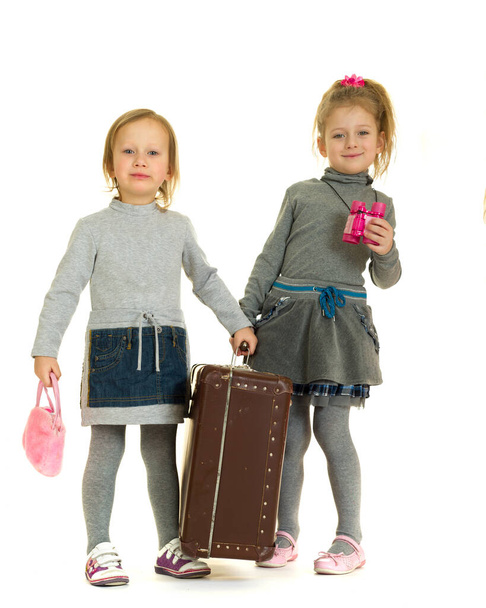 Hymyileviä pikkutyttöjä, joilla on vanha matkalaukku - Valokuva, kuva