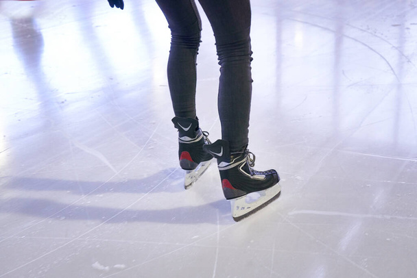Patas de una mujer patinando en una pista de hielo - Foto, imagen