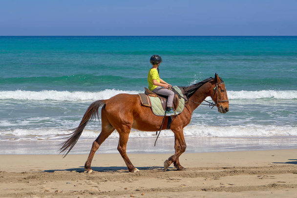 Joven a caballo frente a un mar azul profundo - Foto, Imagen