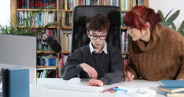 かわいい男の子と母親は家で宿題をするママは息子を助け宿題のやり方を教える。概念教育学学習学。隔離室の男子生徒。眼鏡をかけた思いやりのある母親は少年がコンピュータの家で宿題をするのを助けてくれます - 映像、動画