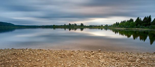 Stone Beach At Drought On A cloudy day Long Exposure and Heavy Clouds At Sunset At Bonnevaux Ονομάζεται επίσης Lac de l 'Entonnoir At Bouverans Bonnevaux Franche Comte Γαλλία - Φωτογραφία, εικόνα