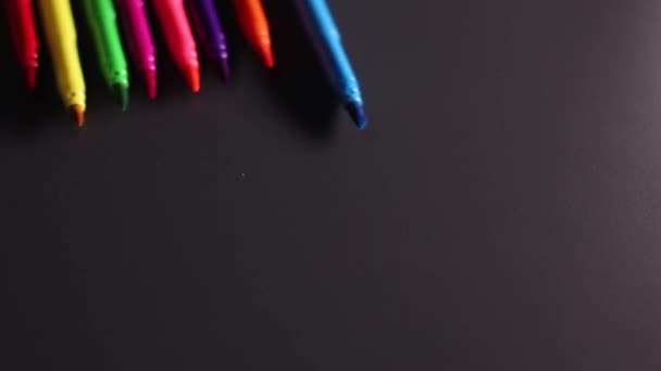 Marcadores multicoloridos brilhantes rolando sobre fundo preto. Arte, dor, escrita, papelaria, gorjeta de feltro. Imagens FullHD de alta qualidade - Filmagem, Vídeo