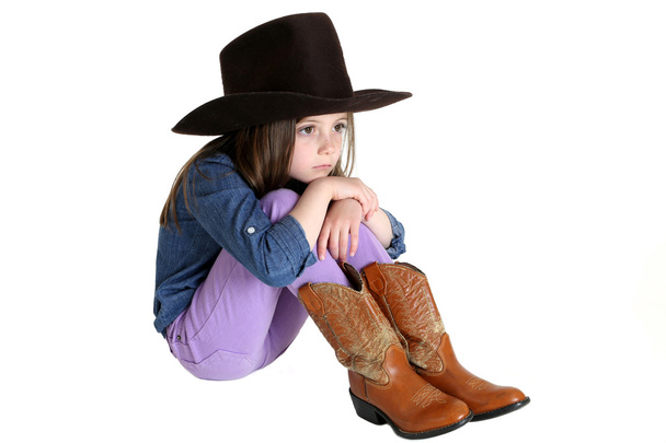 cute young cowgirl sitting with her knees up - Foto, afbeelding