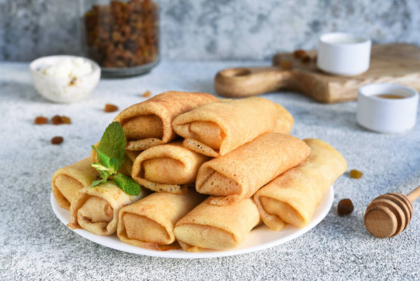Thin spring rolls on a light concrete background. Platbands. National, traditional dish of Belarus and Ukraine. Pancakes - Foto, Imagen