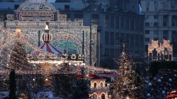 Velký kolotoč na Rudém náměstí v Mosco.Vánoční trh a dekorace ve městě.Velký vánoční stromeček osvětlené brány na Manezhnaya náměstí.Tverskaya ulice na pozadí - Záběry, video