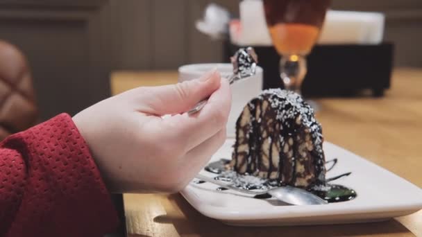 La mujer en la cafetería come pastel con tenedor. Café en las inmediaciones - Metraje, vídeo