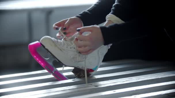 Eislaufen - Frau bindet Schnürsenkel auf weißen Schlittschuhen in der Umkleidekabine - Filmmaterial, Video