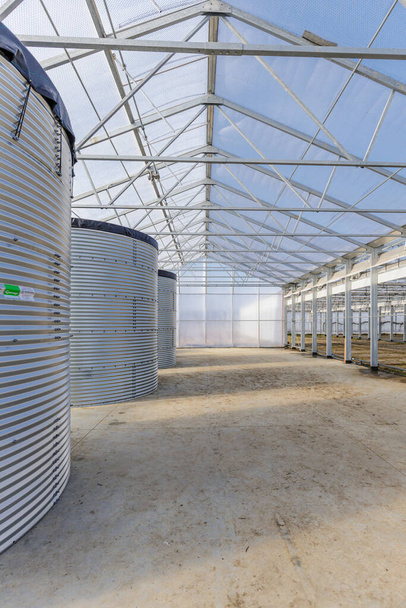 Tres grandes tanques de almacenamiento de agua en el invernadero - Foto, imagen