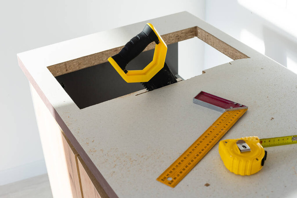 um Löcher in der Küchenarbeitsplatte für Geräte zu schneiden - Foto, Bild