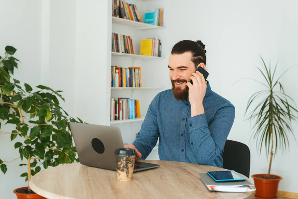 Photo of man in office talking with client at phone - Photo, Image