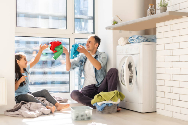 ropa de lavandería familiar multiétnica casual feliz en casa - Foto, imagen