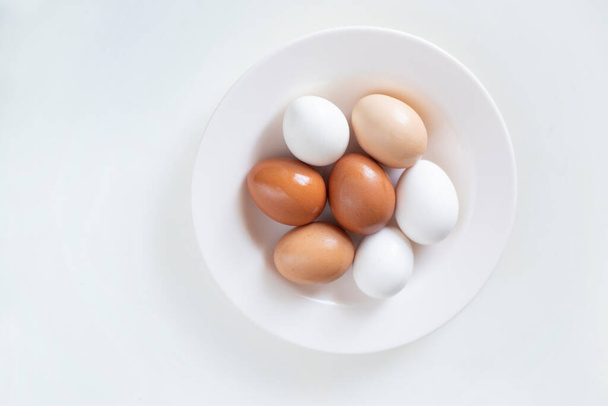 φωτογραφία φόντου για μια συνταγή, αυγά κοτόπουλου βρίσκονται σε ένα πιάτο. Έννοια τροφίμων. - Φωτογραφία, εικόνα