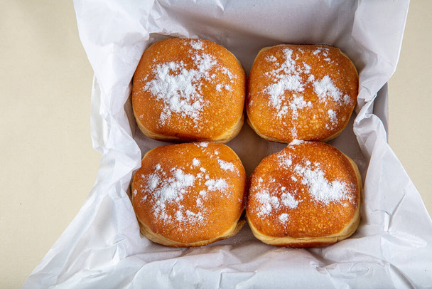 Verse gebakken en gegarneerd met poedersuiker Duitse donuts - Berliner of Krapfen - op witte tafel. - Foto, afbeelding