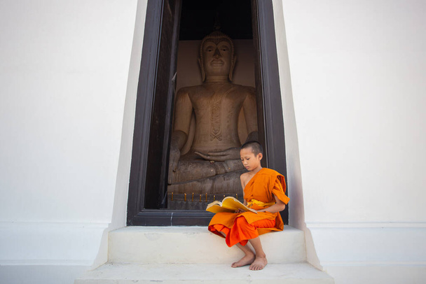 Nuori aloittelija munkki lukemassa kirjaa Wat Phutthai Sawan Temple, Ayutthaya, Thaimaa - Valokuva, kuva