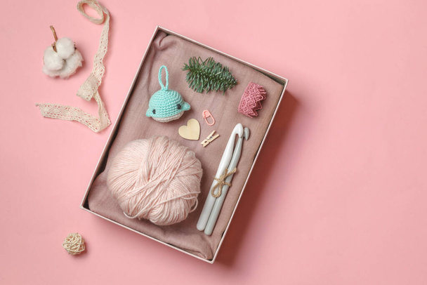 Hygge gift box with a set of crochet and amigurumi keychain. On a pink pastel background with space - Photo, Image