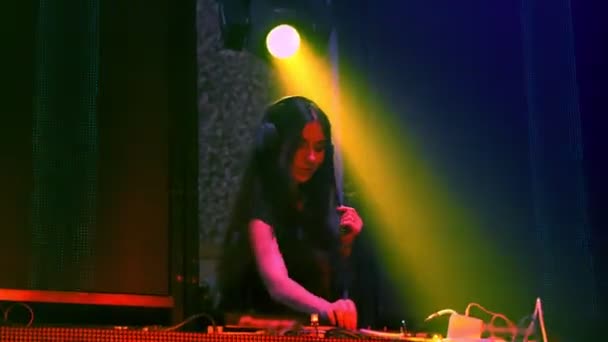 DJ lavalla disco-yökerhossa sekoittamassa tekno-musiikkia - Materiaali, video