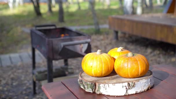 Calabaza naranja y dos tazas en una mesa. Tiempo de temporada de otoño - Imágenes, Vídeo