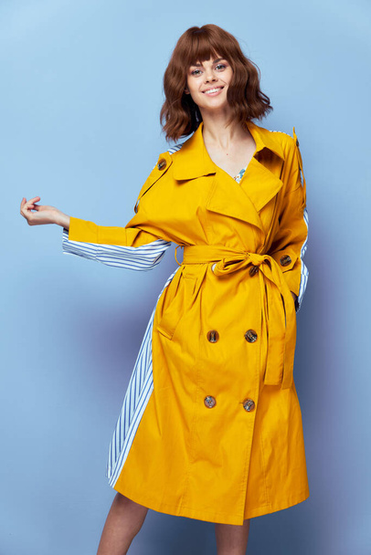 Mujer Sonrisa mano en bolsillo abrigo de rayas amarillas  - Foto, imagen