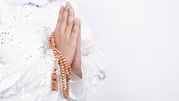 Hands of Asian muslim woman wearing prayer beads welcoming guests / Ied Fitr Greeting in white background - Valokuva, kuva
