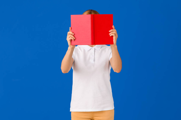 Mature woman with book on color background - Photo, Image