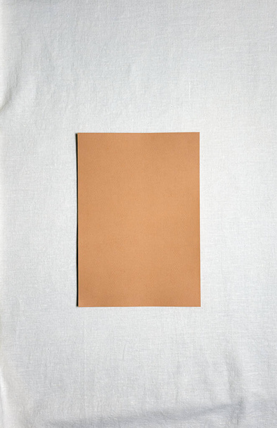 白いリネンのラクダの色の正方形の空白の紙のシート。コピースペース。大きなコピースペースで触覚フラットレイアウトの背景。有機的なデザイン。パステルカラー。垂直方向. - 写真・画像
