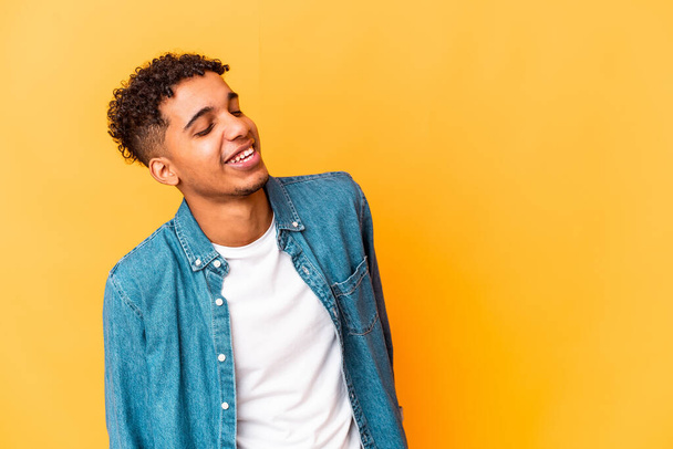 Молодий афроамериканський кучерявий чоловік ізольований на фіолетовому розслабленому і щасливому сміху, шия розтягнута, показуючи зуби
. - Фото, зображення