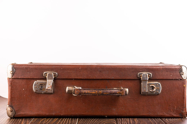 Old suitcase on the table against white background. - Photo, image