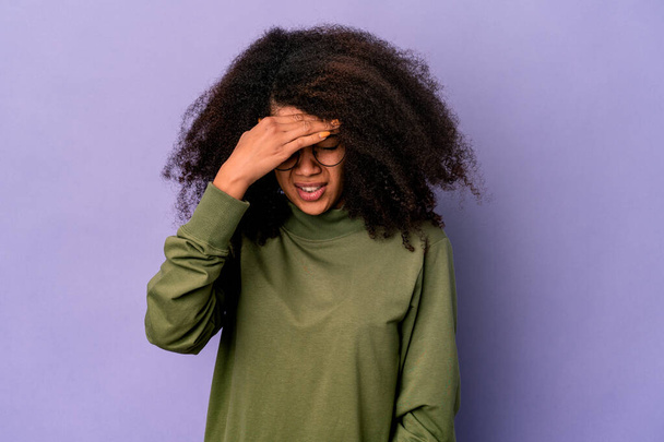 Молодая африканская кудрявая американка, изолированная на фиолетовом фоне с головной болью, касающаяся лица. - Фото, изображение