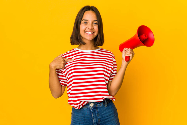 Młoda Latynoska kobieta trzyma megafon wskazując ręcznie na przestrzeń do kopiowania koszuli, dumna i pewna siebie - Zdjęcie, obraz