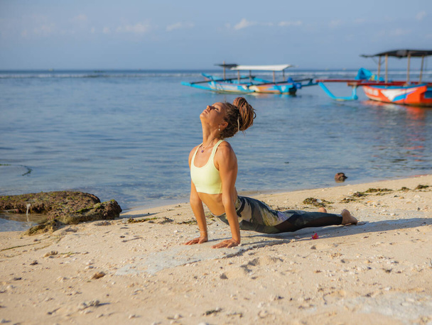 Urdhva Mukha Svanasana, Pose de chien orientée vers le haut. Femme caucasienne pratiquant le yoga sur la plage. Mode de vie sain. Exercice d'étirement. Retraite de yoga. Plage Thomas, Bali, Indonésie - Photo, image