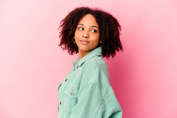 Young african american mixed race woman isolated looks aside smiling, cheerful and pleasant. - 写真・画像