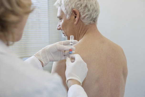 VACCINATING AN ELDERLY PERSON - Photo, image