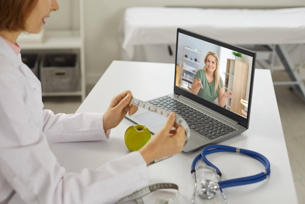 Smiling woman patient asking questions about slimming to woman doctor nutritiologist during online chat - Foto, afbeelding