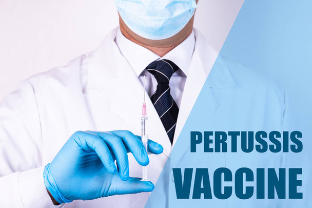Pertussis Vaccine text is written on the background of a doctor who is holding a syringe with a vaccine in a medical mask and gloves. Medical concept. - 写真・画像