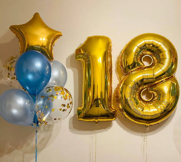 Composition of air helium balloons blue mother-of-pearl, transparent with confetti, gold stars and a large gold number eighteen - Fotografie, Obrázek