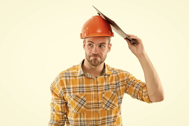 Mind your head. Mind your safety. Builder in safety helmet protect head with clipboard. Construction safety and health. Building safety on site. Safe construction practice. Building and constructing - Fotó, kép