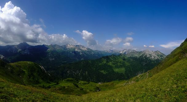горная долина с зелеными холмами и прекрасным панорамным видом на небо - Фото, изображение