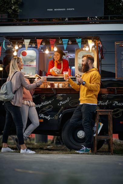 multiethnic group of customers toasting and eating in front of modified truck for mobile fast food service, having fu including employee - Fotoğraf, Görsel