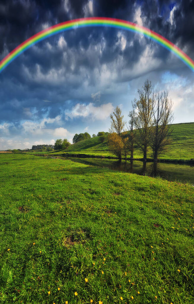 Landschap met een regenboog op de rivier in het voorjaar. kleurrijke ochtend - Foto, afbeelding