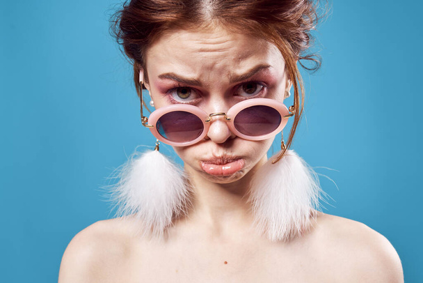 emotional woman wearing dark round glasses naked shoulders decoration closeup isolated background - Photo, Image