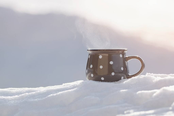 Tasse de thé chaud dans la neige fraîche, fond d'hiver - Photo, image