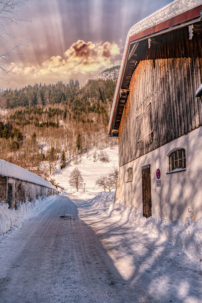 A vertical shot of the narrow road with houses and buildings on the mountain in winter - village - Фото, изображение