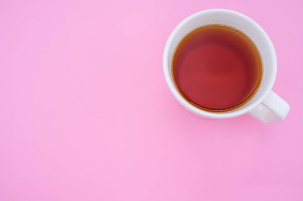 A top view of a white cup of tea isolated on pink background - Fotó, kép