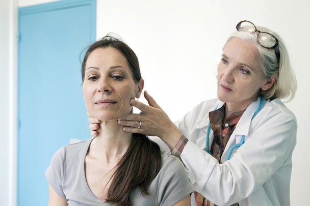 γιατρός εξετάζει το λαιμό γυναίκα - Φωτογραφία, εικόνα