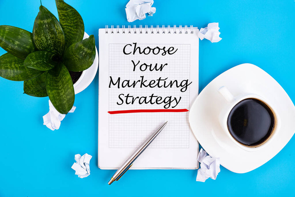 Choose Your Marketing Strategy - handwriting on a notebook with pen and a cup of coffee - Фото, изображение