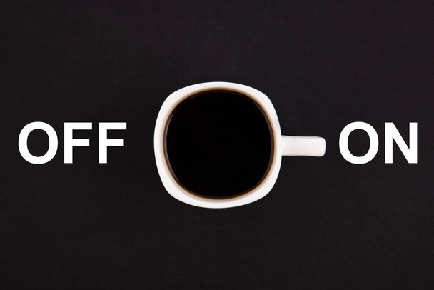 A white cup of coffee is turned on. Concept on a black background. - Valokuva, kuva