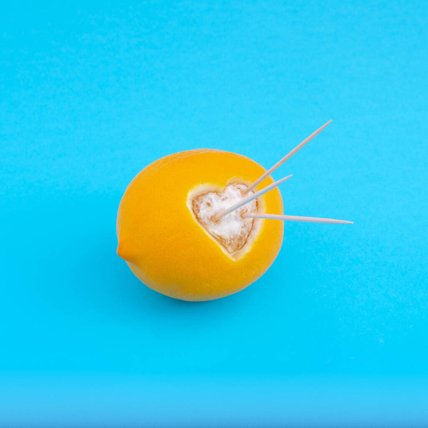 A closeup shot of orange with heart cut shaped isolated on bluebackground - cupid concept - Photo, Image