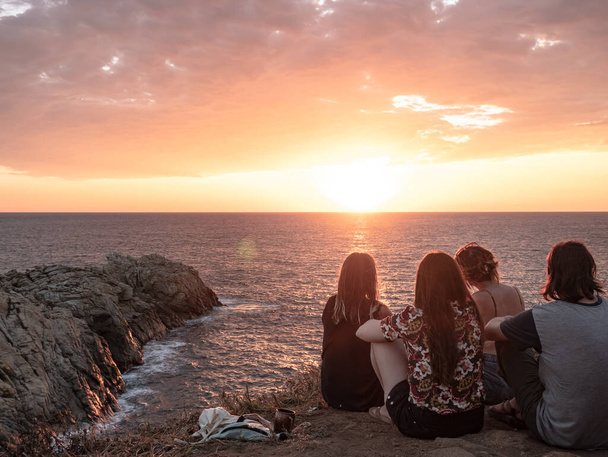 A back view of friends enjoying a magical sunset over a sea, Punta Cometa, Pacific coast of Mexico, Quintana Roo - Foto, Imagen
