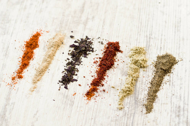 A flat lay of the variety of spices on the white table - Photo, image