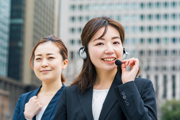Azji biznes kobieta noszenie zestaw słuchawkowy w biznesowej dzielnicy - Zdjęcie, obraz